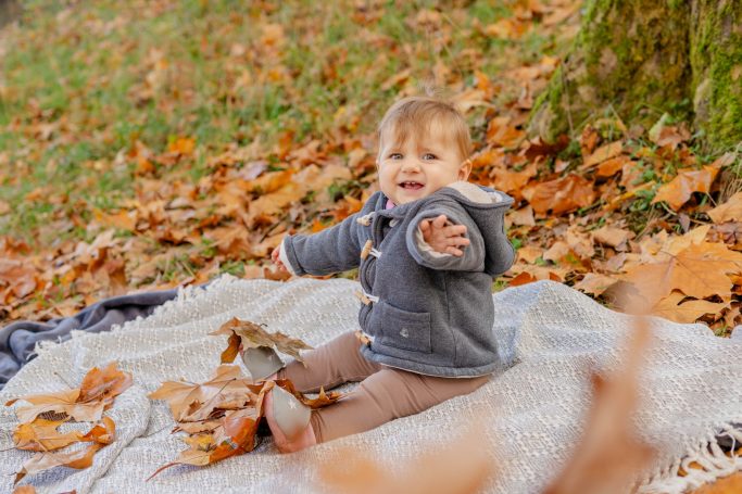kleines Mädchen im Herbstlaub